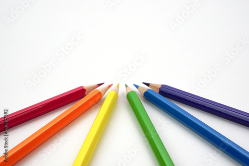Top view of colored pencils or pastel on white background. Learning, study and presentation concept.
