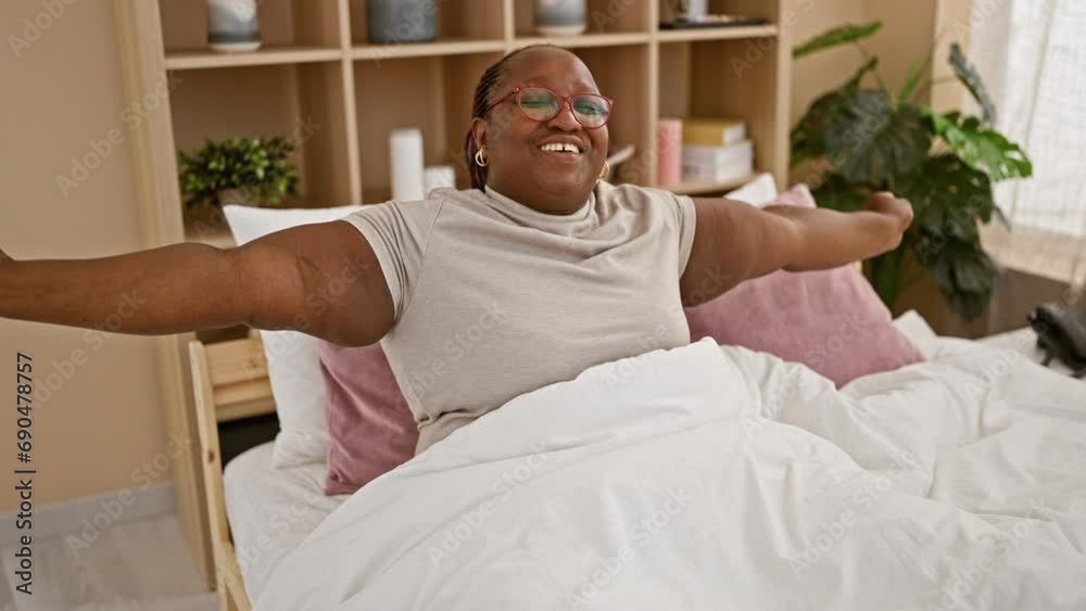 Cheerful african american woman joyfully stretching arms, waking up in cozy bed, relaxing in comfortable bedroom, enjoying morning happiness at home Cheerful african american woman joyfully stretching arms, waking up in cozy bed, relaxing in comfortable bedroom, enjoying morning happiness at home