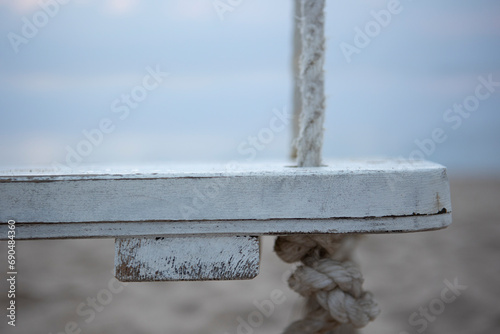 Wooden swing on the beach. The coast of the Indian Ocean. A deserted beach. The concept of summer holidays. Macro photo.