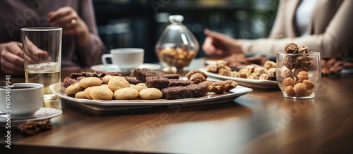 Close-up of people near a table with various snacks during a coffee break.