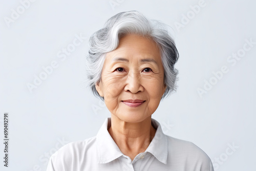 Elder Asian woman on plain background photo