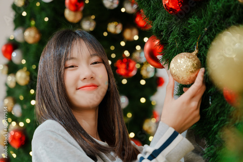 Asian girl take the photo with  Christmas tree decorate  in department store.