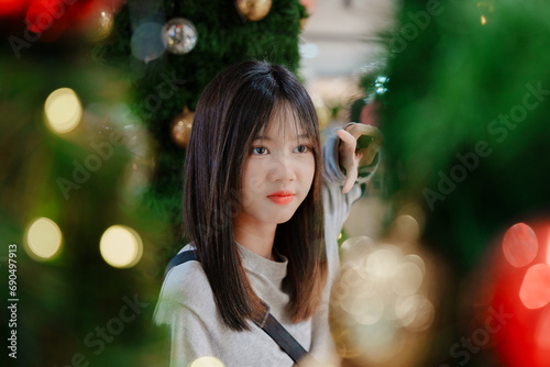 Asian girl take the photo with  Christmas tree decorate  in department store.