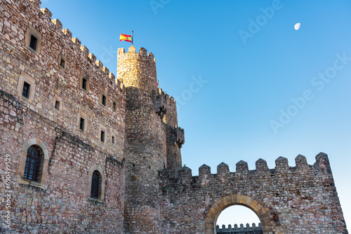 Full moon in the blue sky over the medieval castle of the old town of Siguenza, Spain. photo