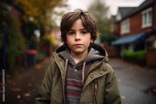 Portrait of a boy in a coat on the street in autumn