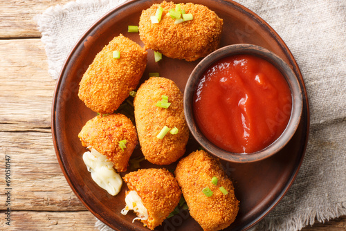 Suppli al telefono Italian snacks consisting of rice with tomato sauce filled with mozzarella, soaked in eggs, coated with bread crumbs and deep-fried closeup. Horizontal top view from above photo