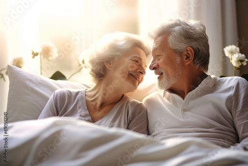 Love lives forever. Senior couple at home. Handsome old man and attractive old woman are enjoying spending time together while lying in bed.