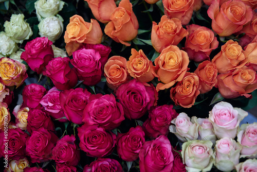 beautiful bouquet of roses in various shades of pink  orange  and white. The roses are arranged in a way that creates a gradient effect from dark pink to light orange