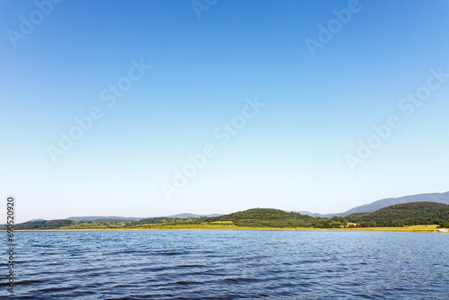 Landscape with lake, hills and empty sky