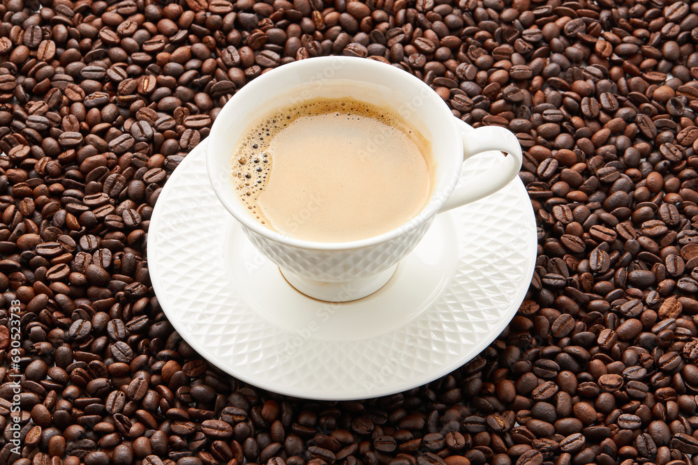 Top view of coffee in white cup place on surface many roasted coffee beans background. Top view of coffee in white cup place on surface many roasted coffee beans background.