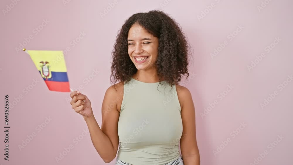 Radiant and confident young hispanic woman, beaming with joy as she proudly holds a colombian flag against an isolated pink wall. Radiant and confident young hispanic woman, beaming with joy as she proudly holds a colombian flag against an isolated pink wall.