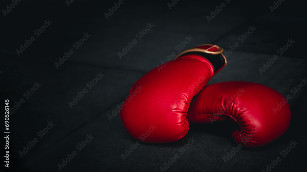 red boxing glove on boxing ring in gym with dark black background. Fight sport concept