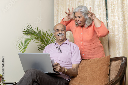 Fotografie Indian senior woman teasing husband in living room , After retirement life enjoy