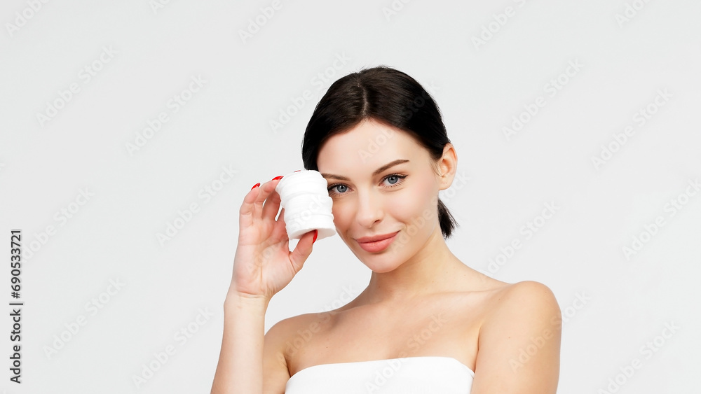 Charismatic, beautiful young woman using a cotton pad on a light isolated background. Concept of clean skin, facial care and natural cosmetics. Charismatic, beautiful young woman using a cotton pad on a light isolated background. Concept of clean skin, facial care and natural cosmetics.