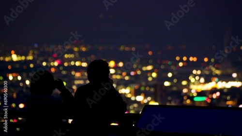 美しい夜の都市風景を眺めながらデートをする恋人たち
