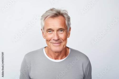 Portrait of a smiling senior man looking at camera isolated on grey background