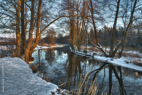 landscape winter trees and fields covered by snow in Poland, Europe on sunny day in winter, amazing clouds in blue sky , river valley