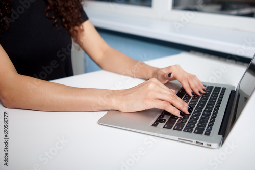 Closeup portrait of woman's hand typing on computer keyboard photo