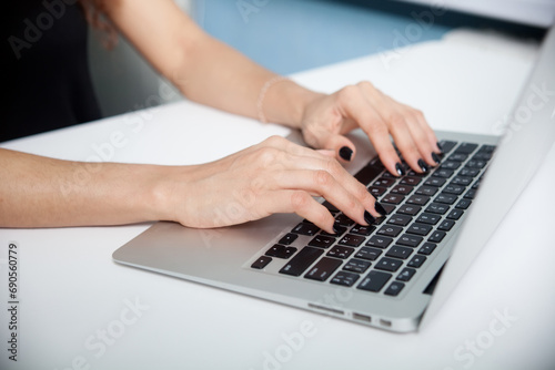 Closeup portrait of woman's hand typing on computer keyboard photo