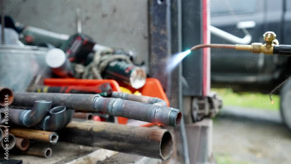 handyman welding metal pipes, metalworking and welding in garage or in construction site handyman welding metal pipes, metalworking and welding in garage or in construction site