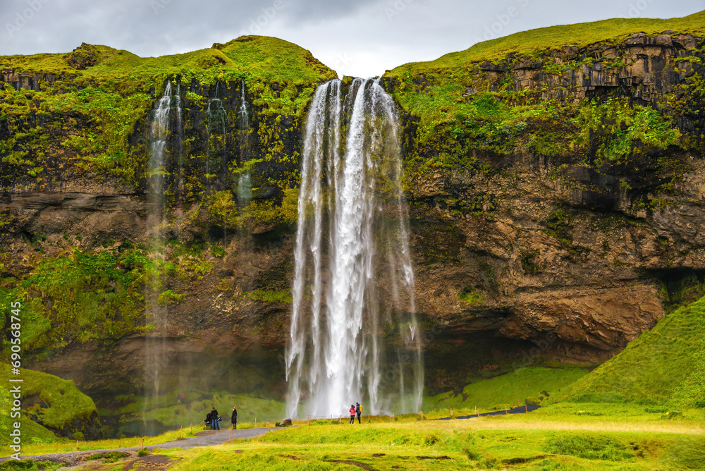 Seljalandsfoss, Iceland, one of the biggest waterfall in Iceland Seljalandsfoss. Beautiful Icelandic landscape, huge cliff, dramatic sky and tourists Seljalandsfoss, Iceland, one of the biggest waterfall in Iceland Seljalandsfoss. Beautiful Icelandic landscape, huge cliff, dramatic sky and tourists