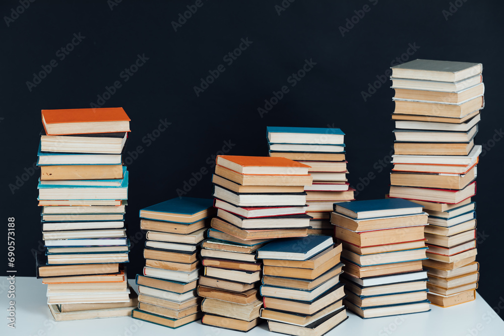 Stacks of old educational books in library on black background Stacks of old educational books in library on black background