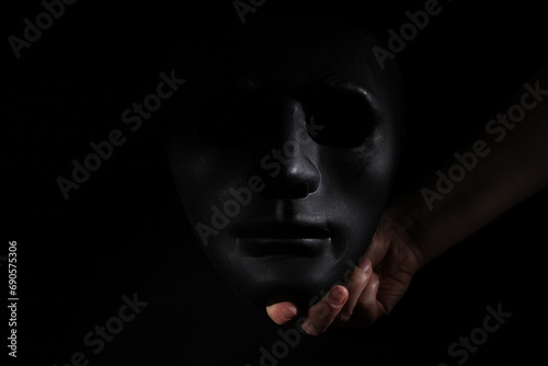 black face mask in hand, theatrical symbolism, stage presence at a drama festival