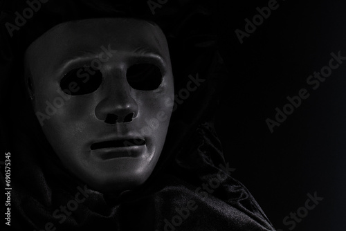 black face mask in fabric, vintage elegance, art on stage, Drama and theatre, black background, dramatic presence at an event
