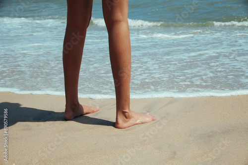 female feet in the sand of sea