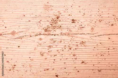 Texture of sea sand on a natural wooden background. View from above. Trendy color of year 2024 - Peach Fuzz.