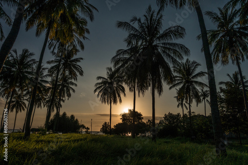 Sunset view of a beach on Lombok island, Indonesia with the silhouette of palm trees in the foreground