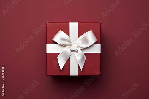Top view of burgundy red Christmas or Valentine gift box with white ribbon photo