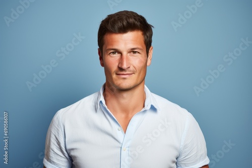 Portrait of a handsome man in a white shirt on blue background