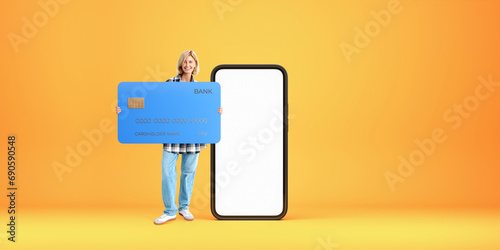 Happy woman with big credit card and blank smartphone screen