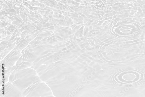 White water with ripples on the surface. Defocus blurred transparent white colored clear calm water surface texture with splashes and bubbles. Water waves with shining pattern texture background.