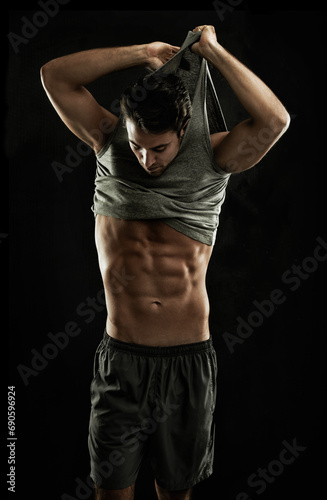 Off, black background or shirt of man with six pack, strong abs or stomach in studio for fitness. Model, cool guy or ripped male person with healthy body, dark shadow or abdomen muscle for wellness © Jeff Bergen/peopleimages.com
