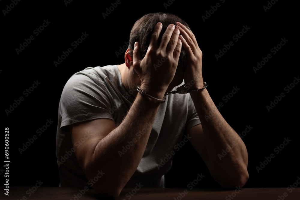 Man, criminal and handcuffs for interrogation, crime or money laundering in arrest on table in room. Man, criminal and handcuffs for interrogation, crime or money laundering in arrest on table in room.