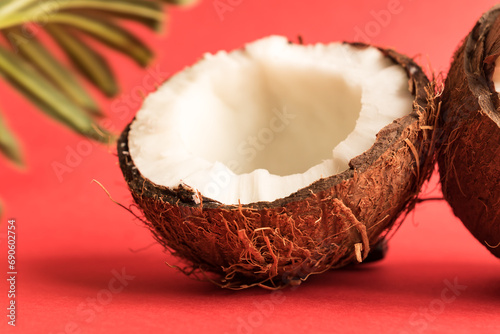 Half of fresh raw coconut on red backgound.