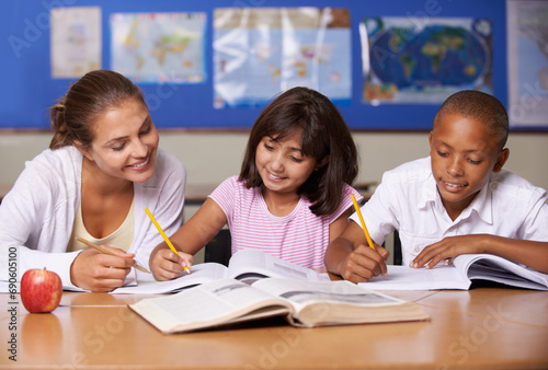 Teacher, books and school kids in classroom, writing or learning together for development, studying or knowledge. Woman, children and help with notebook with support, teaching or education with smile