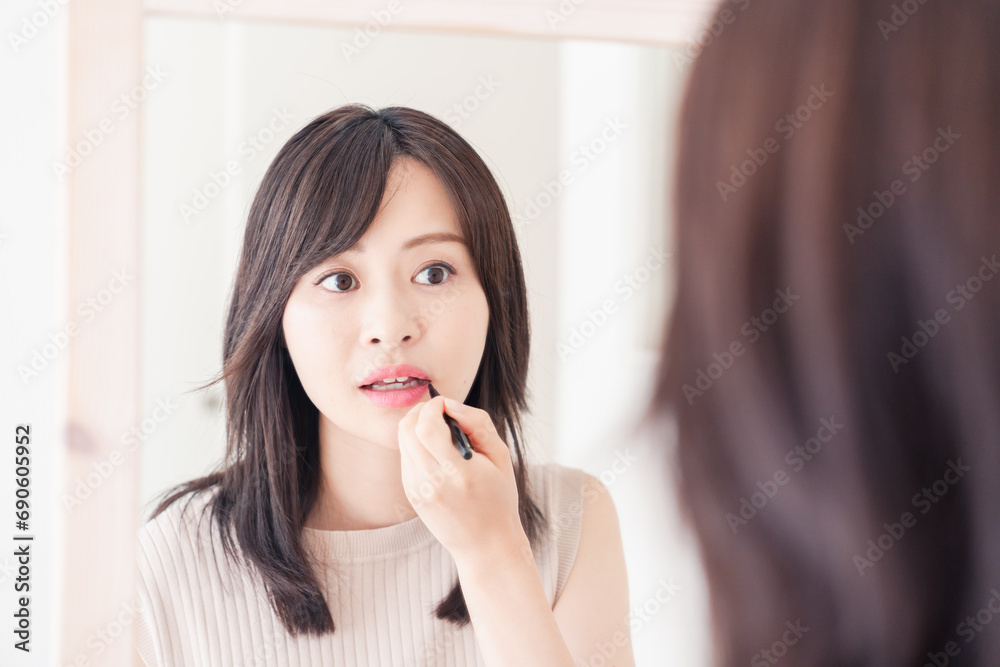 家でメイクをする若い女性 家でメイクをする若い女性