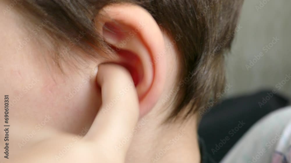 A child with an ear infection picks his ear with his finger, expressing that he is in pain.A child with ear pain picks his ear with his finger, A child with an ear infection picks his ear with his finger, expressing that he is in pain.A child with ear pain picks his ear with his finger,