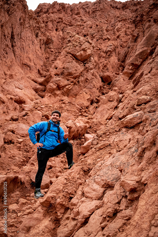 Aventurero escalando uno de los cerros colorados en la localidad de Purmamarca, en Jujuy