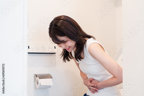 トイレでひどい腹痛に苦しむ若い女性 photo
