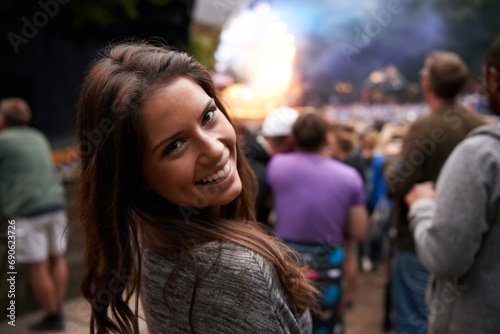 Excited woman, portrait and face at outdoor music festival for party, event or DJ concert in nature. Closeup of female person smile in crowd at night for carnival, performance or summer fest outside