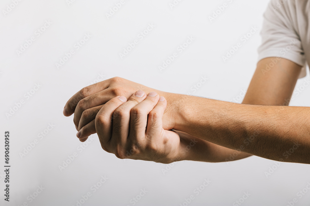 A sad Asian man, his wrist in pain, possibly due to carpal tunnel syndrome, reflects the challenges of arm discomfort. Studio shot isolated on white, illustrating health care and medical issues. - obrazy, fototapety, plakaty 