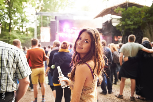 Woman, portrait and drink at outdoor music festival with crowd for party or event in nature. Face of female person smile and enjoying sound or audio at carnival, concert or performance outside