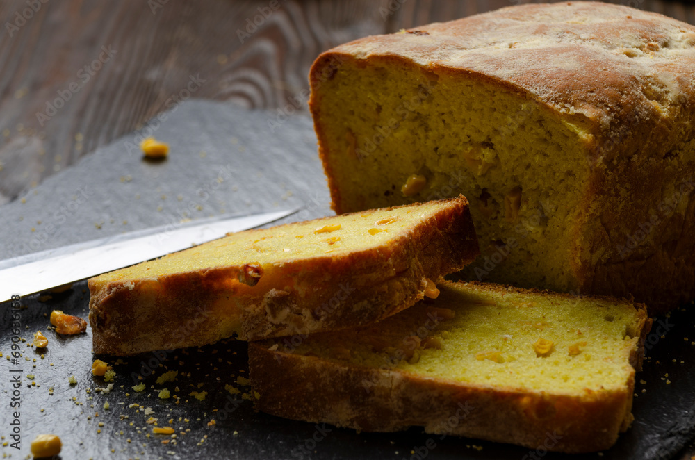 Homemade cornbread loaf and slices on kitchen table