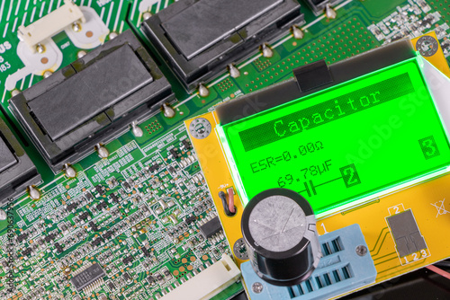 Measuring the capacitance of an electrolytic capacitor. Microcircuit on a black background. Electronic components. Microfarats.