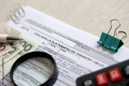 Declaration for tax on goods and services VAT-8 form on accountant table with pen and polish zloty money bills close up photo