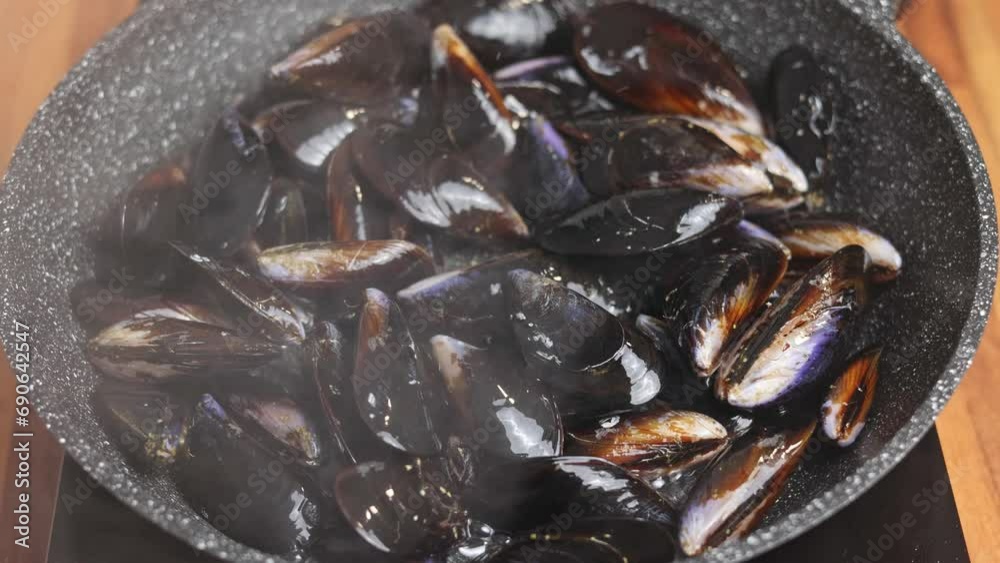 Close-up of cooking Mediterranean mussels in a frying pan at home Close-up of cooking Mediterranean mussels in a frying pan at home